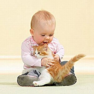 Маленький ребенок играет с котом фото